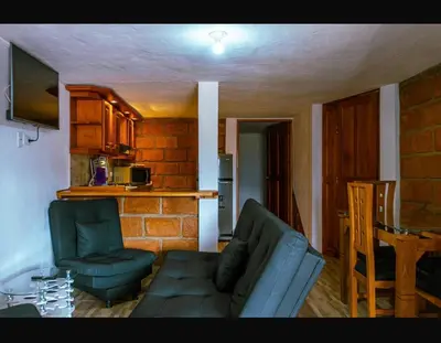 a living room with a couch and chairs and a kitchen at Suite Doble Especial in Jericó