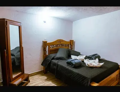 a bedroom with a bed and a mirror at Suite Doble Especial in Jericó