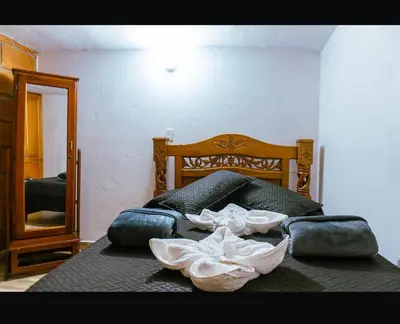 a bed with two pillows and a mirror in a room at Suite Doble Especial in Jericó