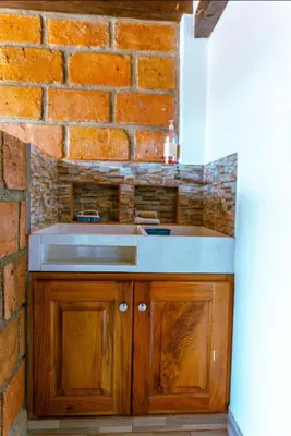 a kitchen with a sink and a brick wall at Suite Doble Especial in Jericó