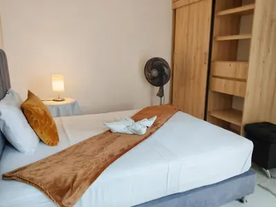 a bedroom with a bed with a blanket and a fan at Casa Hotel La Bonita in Medellín