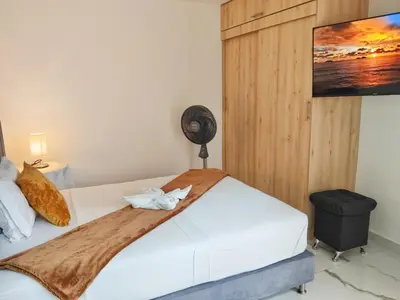 a bedroom with a white bed with a fan at Casa Hotel La Bonita in Medellín