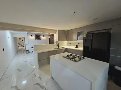 a kitchen with a white counter and a black refrigerator at Casa Hotel La Bonita in Medellín