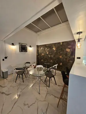 a room with tables and chairs and a wall at Casa Hotel La Bonita in Medellín