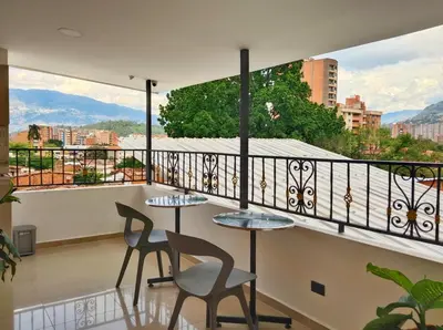 a balcony with two tables and chairs and a view at Casa Hotel La Bonita in Medellín