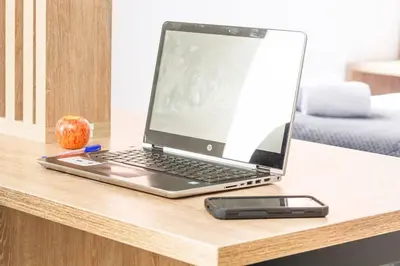a laptop computer on a desk with an apple and a cell phone at NEW! Homey Loft El Tesoro-Fast Wifi in Medellín
