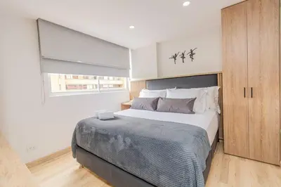 a bedroom with a large bed and a window at NEW! Homey Loft El Tesoro-Fast Wifi in Medellín