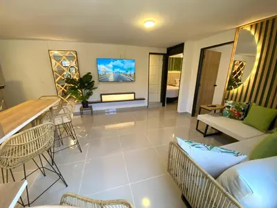 a living room with a couch and a tv at 'SELECT' Medellin in Medellín