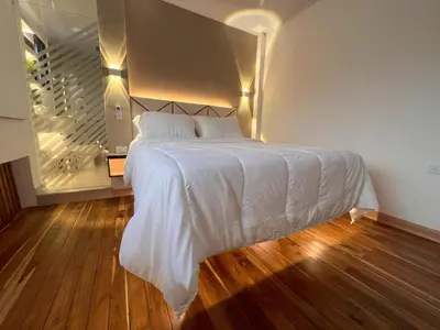 a bedroom with a white bed and a staircase at 'SELECT' Medellin in Medellín