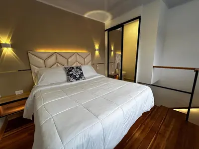 a bedroom with a large white bed and a desk at 'SELECT' Medellin in Medellín