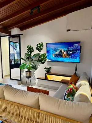 a living room with a couch and a tv on the wall at 'SELECT' Medellin in Medellín