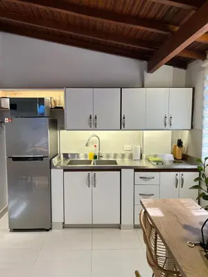 a kitchen with white cabinets and a stainless steel refrigerator at 'SELECT' Medellin in Medellín