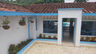 a white house with a blue door and windows at Finca Villa Maria in La Pintada