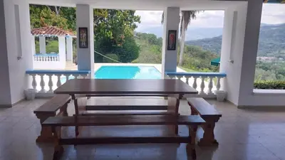 a dining room with a table and a swimming pool at Finca Villa Maria in La Pintada