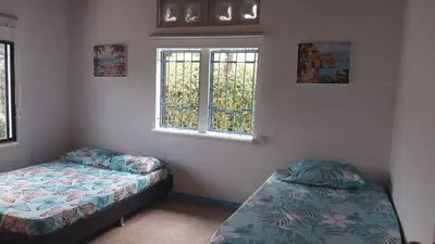 a bedroom with two beds and two windows at Finca Villa Maria in La Pintada