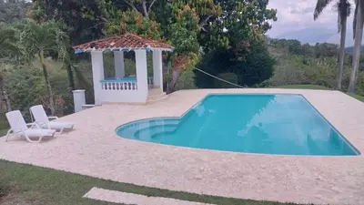a swimming pool with a gazebo next to a house at Finca Villa Maria in La Pintada