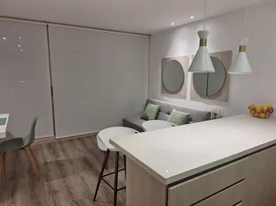 a white kitchen with a couch and a table at Apartamento Manizales II in Manizales