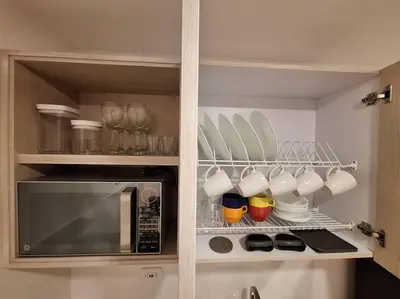 a kitchen with a microwave and cups and plates at Apartamento Manizales II in Manizales