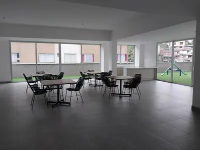 a classroom with tables and chairs and a playground at Apartamento Manizales II in Manizales