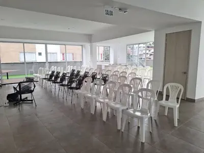 a room with rows of white chairs and tables at Apartamento Manizales II in Manizales