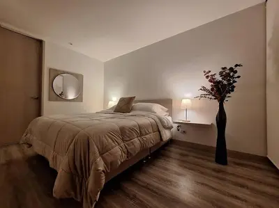 a bedroom with a bed and a vase with flowers at Apartamento Manizales II in Manizales
