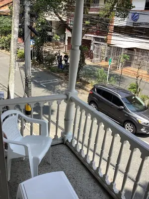 a balcony with a white railing and a car on a street at Accommodation HOUSETEL COCOON Medellin in Medellín