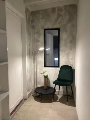 a green chair and a table with a mirror at Accommodation HOUSETEL COCOON Medellin in Medellín