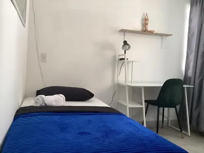 a bedroom with a bed and a desk and a chair at Accommodation HOUSETEL COCOON Medellin in Medellín