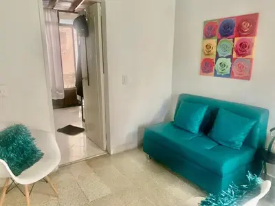 a living room with a blue couch and a chair at Accommodation HOUSETEL COCOON Medellin in Medellín