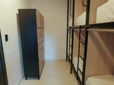 a room with two bunk beds and a closet at La Familia Hostel - Manila in Medellín