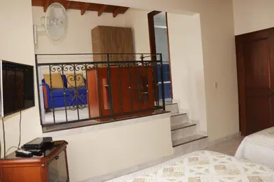 a room with a bed and a staircase with books at Mayorca Homestay in Medellín