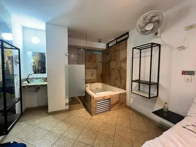 a bathroom with a bath tub and a sink at Hotel Natural Medellin in Medellín