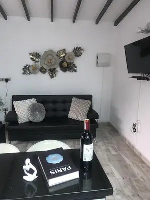 a bottle of wine on a table in a living room at moderno y nuevo aparta estudio en Laureles in Medellín