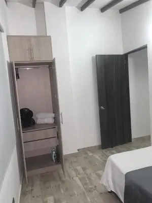 a room with a bed and a closet with a door at moderno y nuevo aparta estudio en Laureles in Medellín