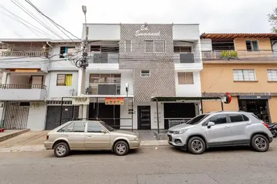 two cars parked in a parking lot in front of a building at moderno y nuevo aparta estudio en Laureles in Medellín