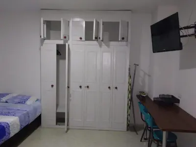 a bedroom with white cabinets and a bed and a table at usoinmobiliario in Medellín