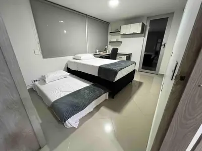 a small bedroom with two beds and a desk at Apto 4 habitaciones privadas 140mtros in Medellín