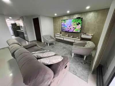 a living room with a couch and a tv at Apto 4 habitaciones privadas 140mtros in Medellín