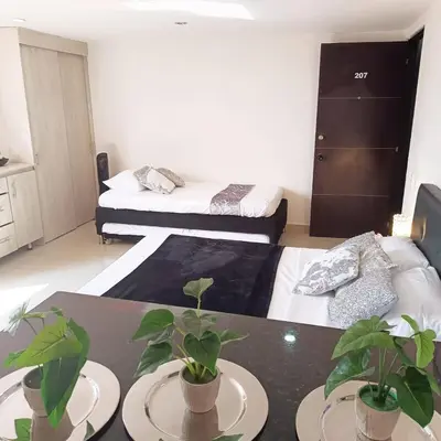 a living room with two beds and a table with plants at El Poblado acomodación familiar hasta 6 personas in Medellín
