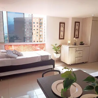 a bedroom with a bed and a table and a window at El Poblado acomodación familiar hasta 6 personas in Medellín