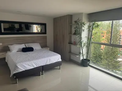 a bedroom with a bed and a large window at Poblado 1 hasta 4 personas in Medellín