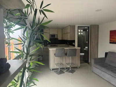 a kitchen and living room with a counter and stools at Poblado 1 hasta 4 personas in Medellín