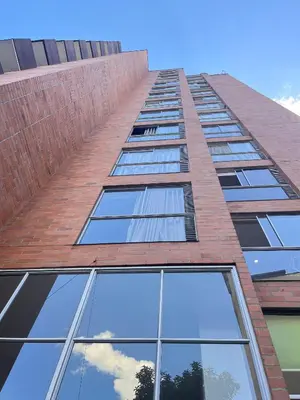 a tall red brick building with glass windows at Poblado 1 hasta 4 personas in Medellín