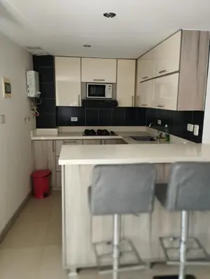 a kitchen with a counter and two chairs in it at Poblado 1 hasta 4 personas in Medellín