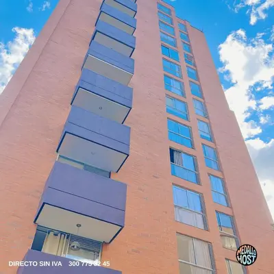 a tall red brick building with blue windows at Poblado 1 hasta 4 personas in Medellín
