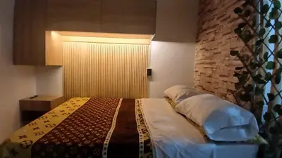 a bedroom with a bed and a brick wall at Apartaestudio Rionegro cerca Aeropuerto in Rionegro