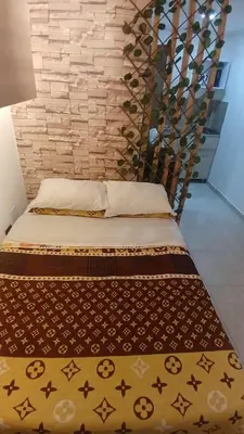 two beds in a room with a brick wall at Apartaestudio Rionegro cerca Aeropuerto in Rionegro