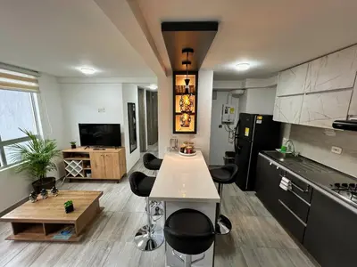 a kitchen with a table and some black appliances at Lindo y disponible Apartamento camino a termales in Manizales