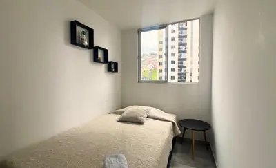 a small bedroom with a bed and a window at Lindo y disponible Apartamento camino a termales in Manizales