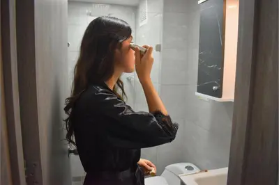 a woman standing in a bathroom brushing her teeth at Lindo y disponible Apartamento camino a termales in Manizales